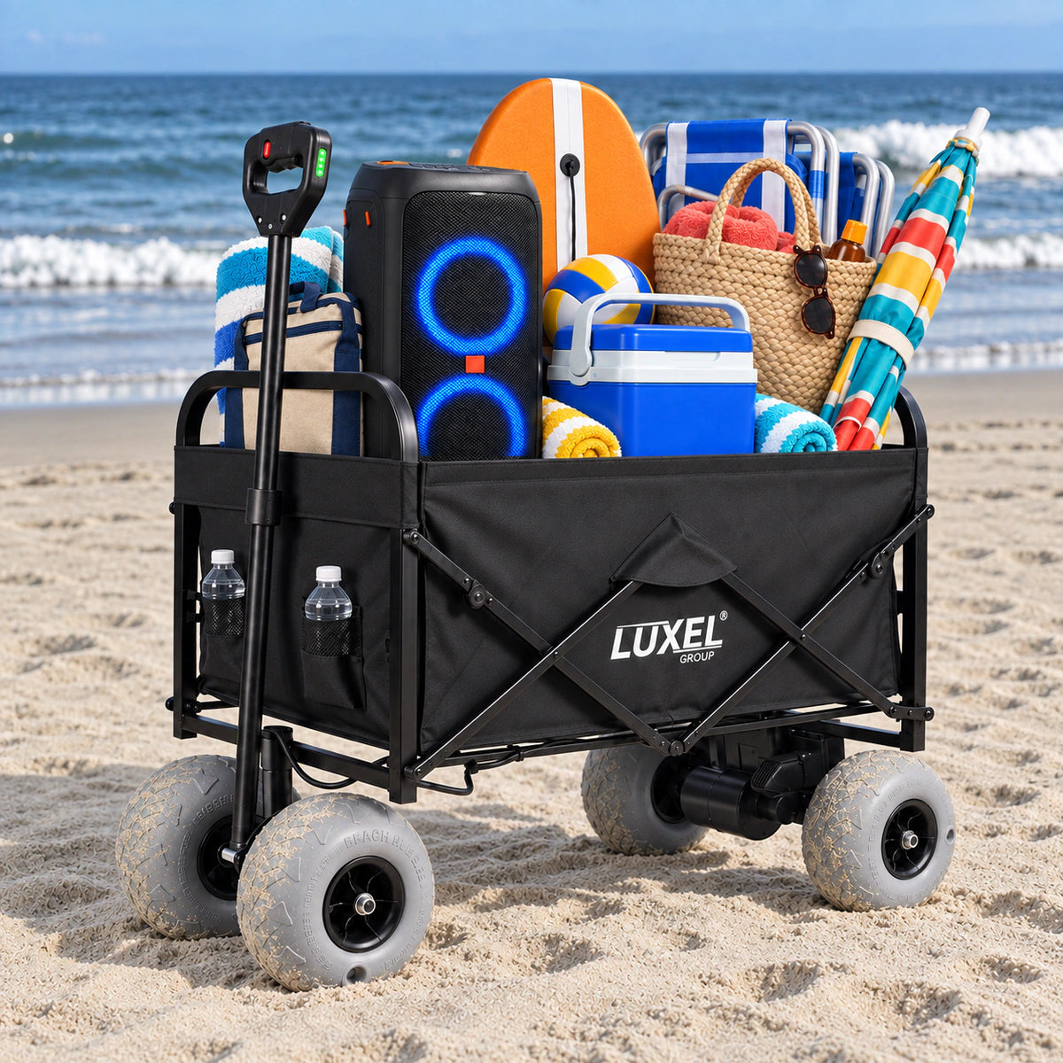 Black LUXEL 500W electric beach wagon on sand, packed with a blue-lit speaker, cooler, woven beach bag, board, chairs and striped umbrella.