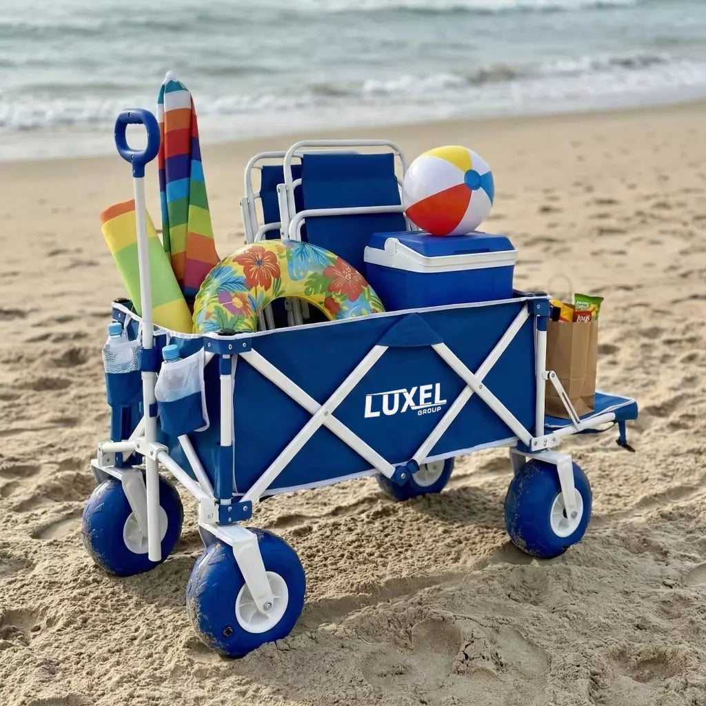 Blue beach cart with toys and a cooler on a sandy beach