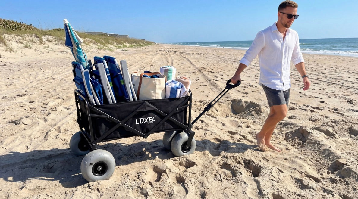 Man pushing a Luxel beach wagon on a sandy beach with ocean view